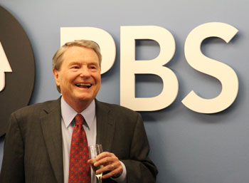 Jim Lehrer smiling with champagne glass