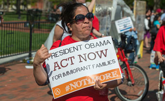 Protestor with "act now" sign