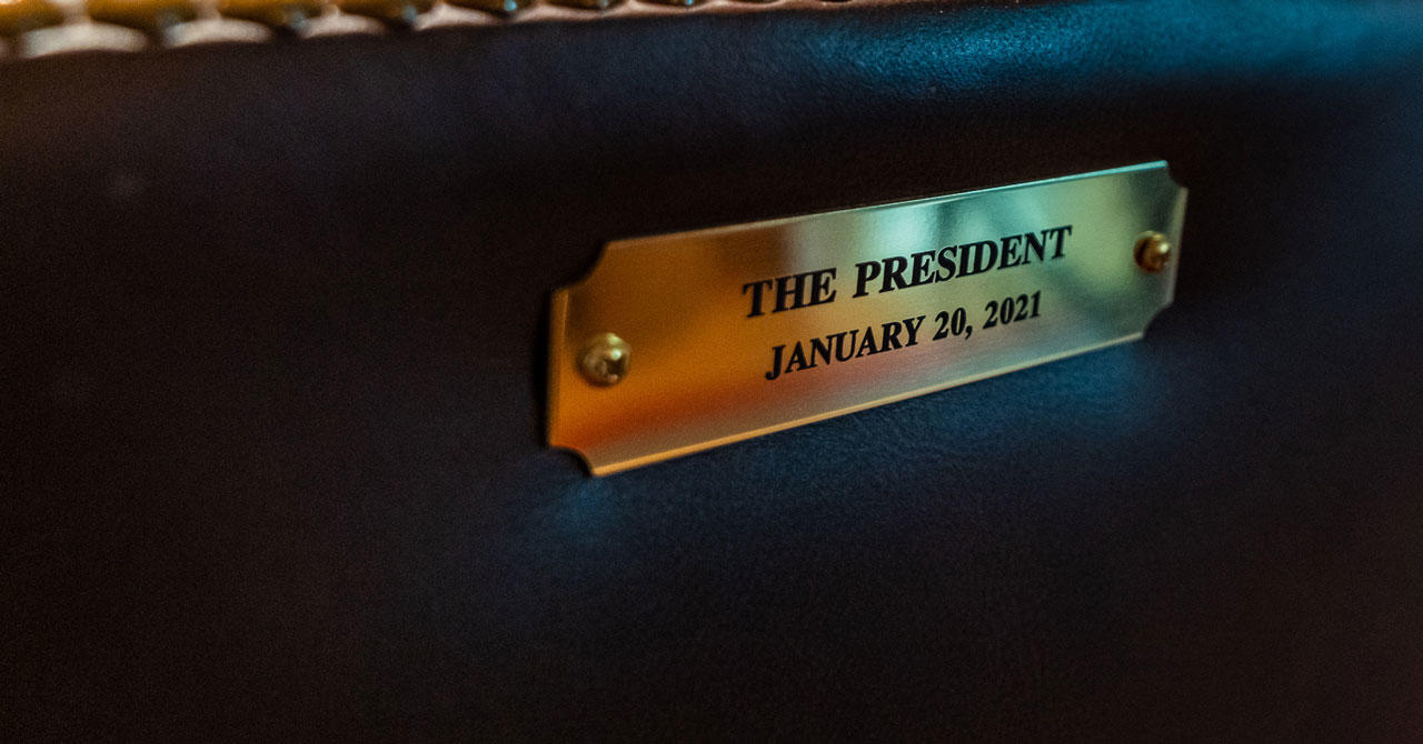 Gold plate on back of chair that says "the president"