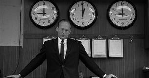 McGeorge Bundy with 3 clocks in background 9:00 Washington, 1:00 GMT, 9:00 Presidential.