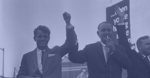 Robert Kennedy raises his arm with President Lyndon Johnson at a campaign event