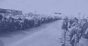 Clergy members and supporters knee on the road, while police and reporters watch in Selma