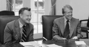 President Jimmy Carter and Zbigniew Brzezinski sitting at a table.