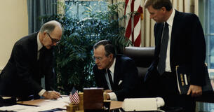 Brent Scowcroft makes notationss in the Oval Office with President George H. W. Bush and Vice President Dan Quayle