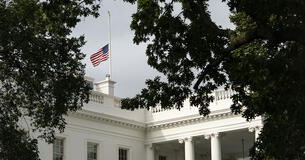 The United States Flag flying at half-staff above the White House
