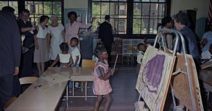 Lady Bird Johnson gets a tour of a classroom with students in it