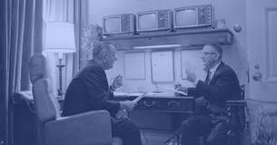 President Johnson and Wilbur Mills talking at a desk