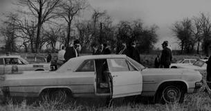 Law enforcement agents inspect the crime scene surrounding Viola Liuzzo's car.