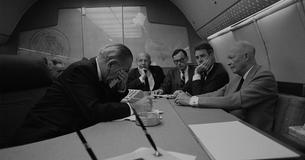 LBJ sitting around a table on Air Force One with former President Eisenhower