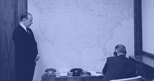 Abe Fortas stands next to LBJ who is sitting and on the phone