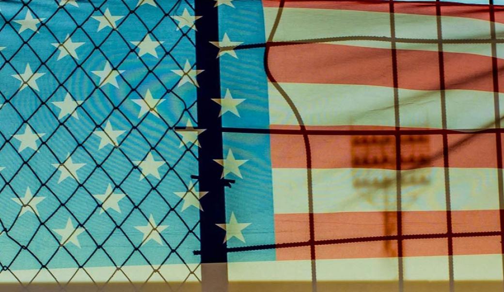 Flag behind border fence