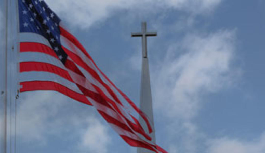 American flag; steeple in the background