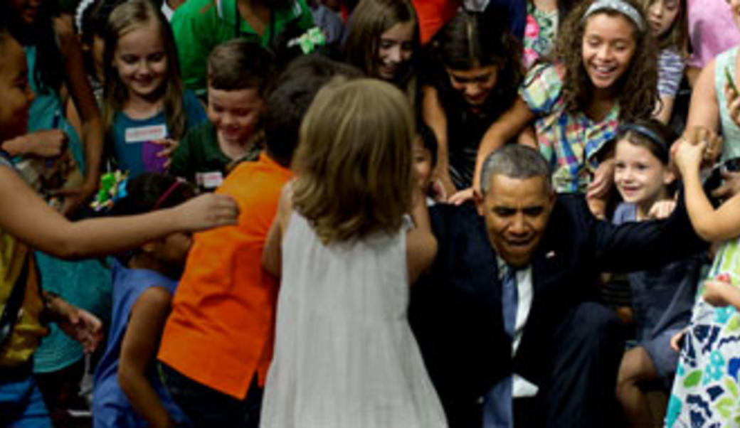 President Obama with a group of children, his arms outstretched