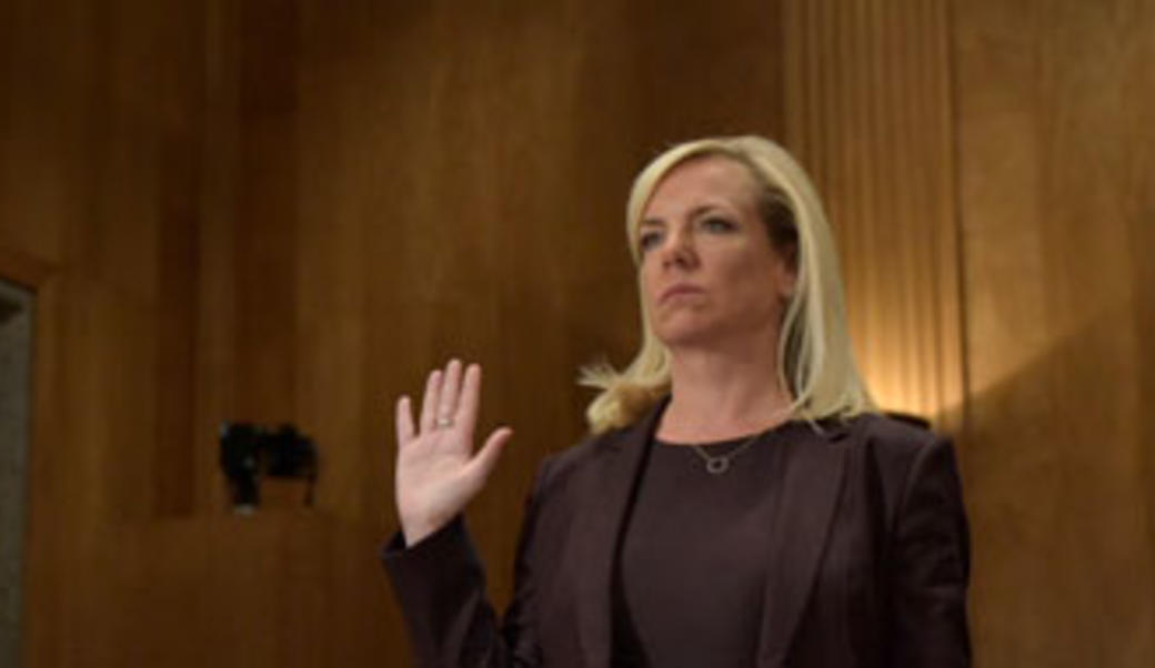 Kirstjen Nielsen with right hand raised