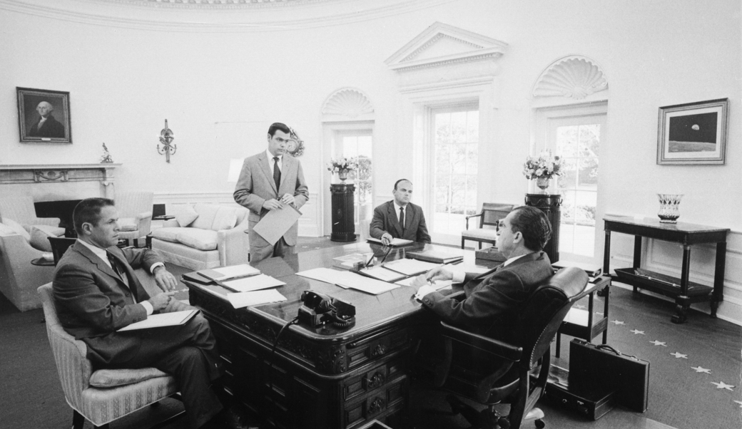 President Nixon sitting around desk with chief advisers