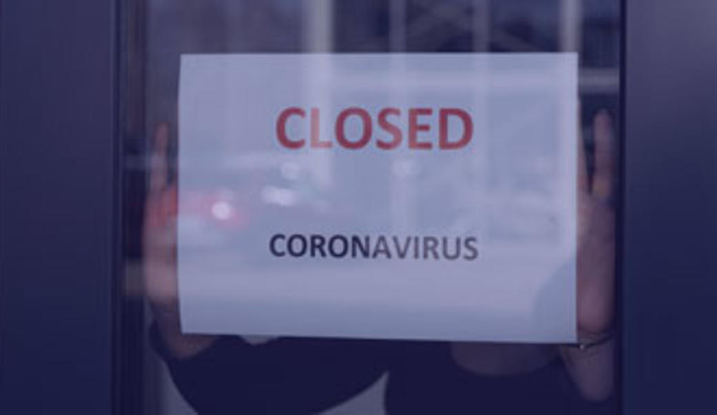 Shopkeeper posts a sign that a business is closed due to coronavirus