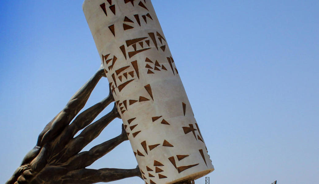 Sculpture: hands pushing up a column