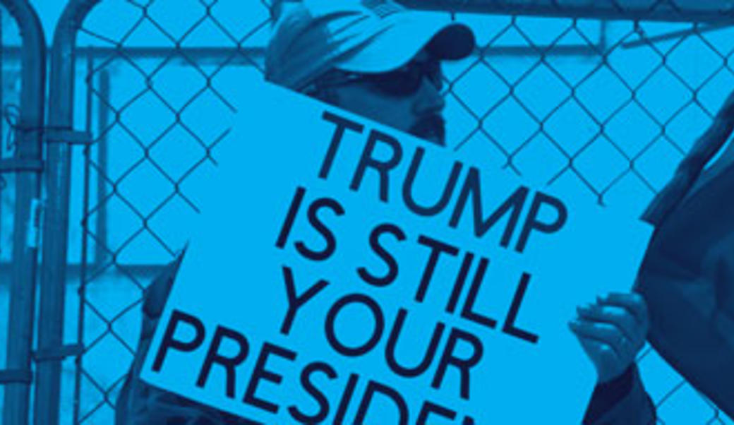Man with "Trump is still your president" sign