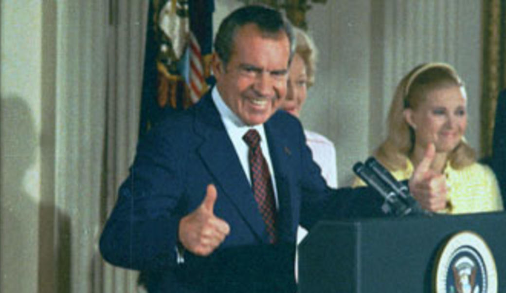 Richard Nixon giving a thumbs-up at presidential lectern