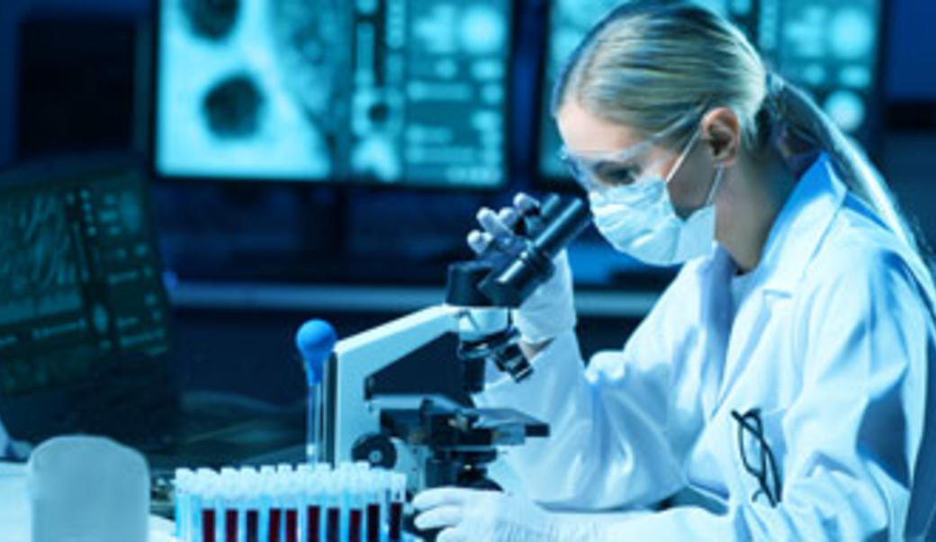 Covid researcher looking through maginfying glass