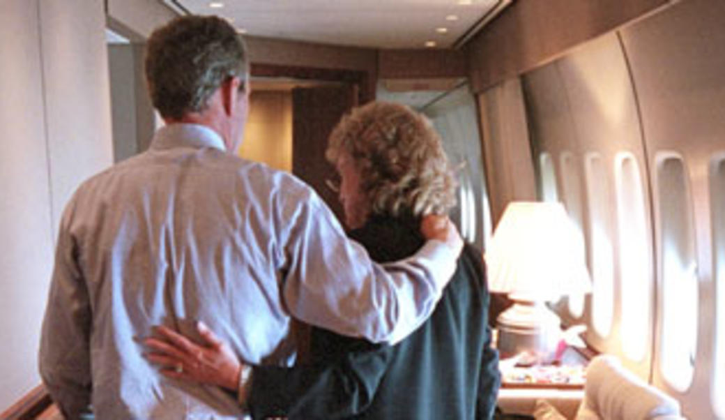 George Bush and Harriet Miers with arms around each other on a plane