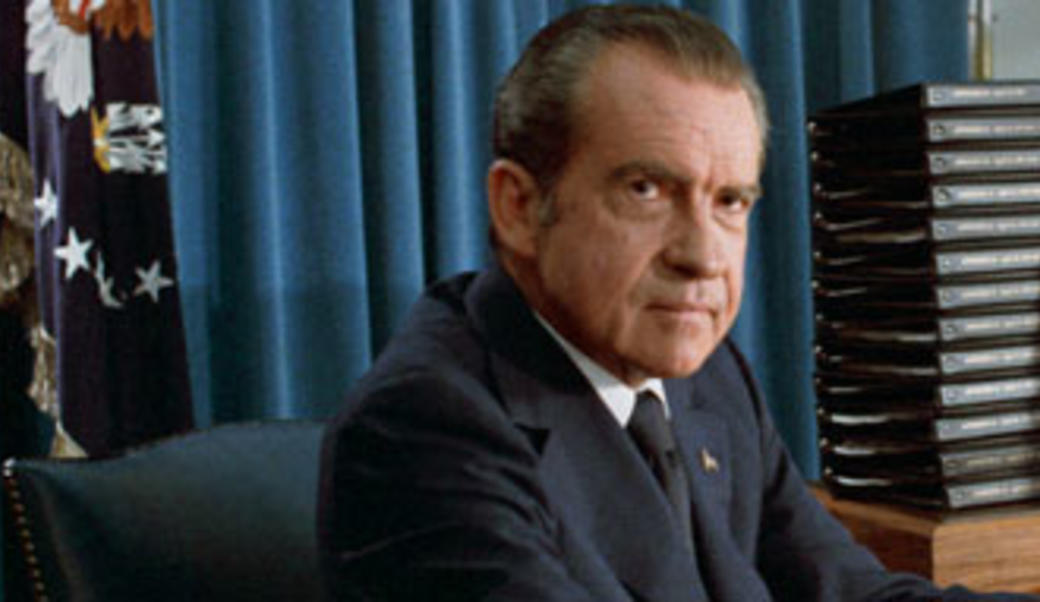 Richard Nixon in front of a stack of transcripts