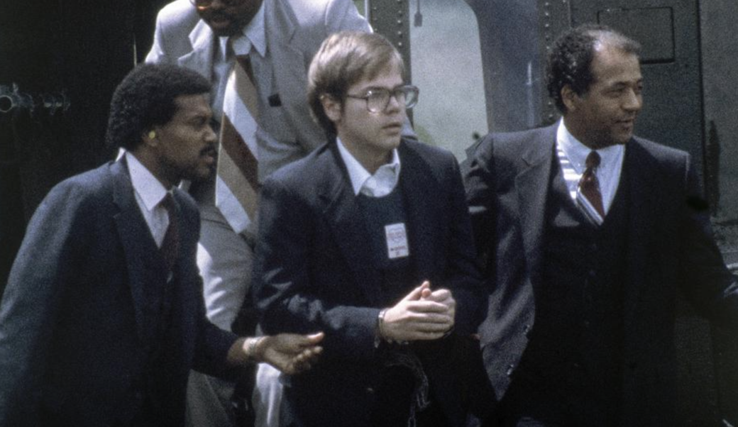 photograph of John Hinckley, Jr. with two United States marshalls