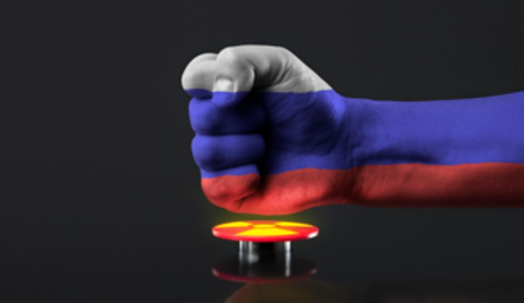Fist on top of nuclear button with Russian flag superimposed
