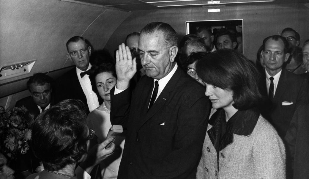 Lyndon B. Johnson taking the oath of office next to Jackie Kennedy on Air Force One