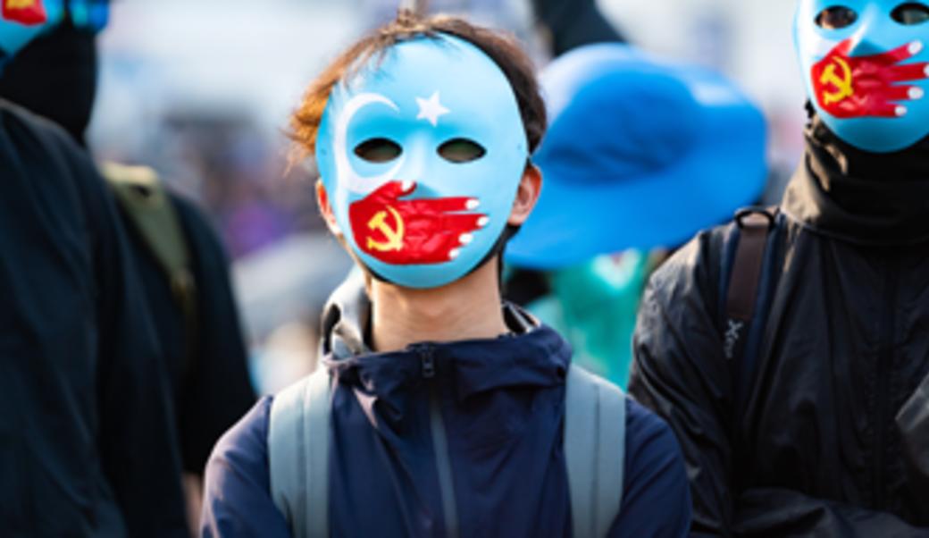  Hong Kong protestors wear masks symbolizing the Communist Party of China's silencing of Uyghur Muslims