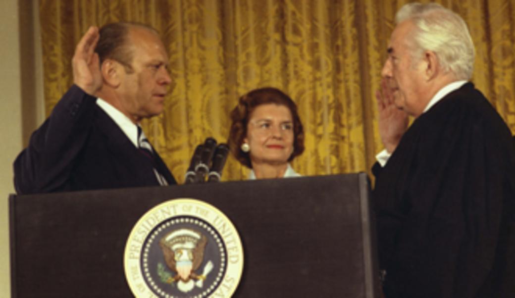 Gerald Ford is sworn in as 38th president of United States by Chief Justice Warren Burger, with Mrs. Ford looking on.