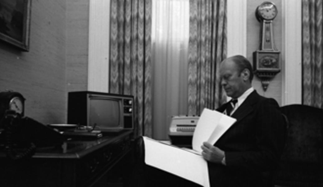 President Ford reviewing text of his pardon of former President Nixon before the public announcement.