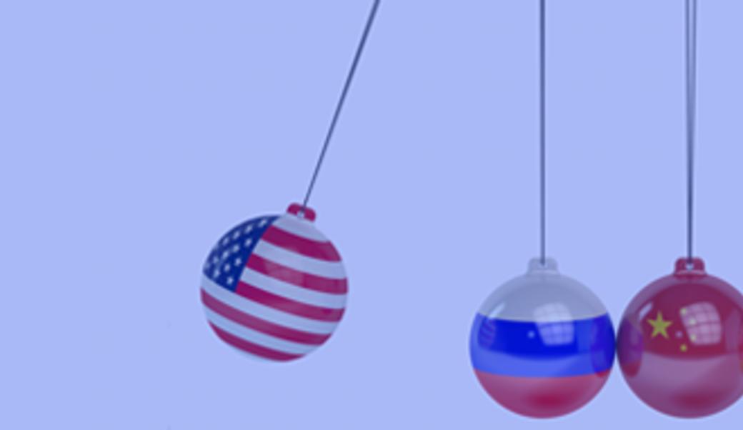 U.S., Russian, and Chinese flags on desktop swinging balls