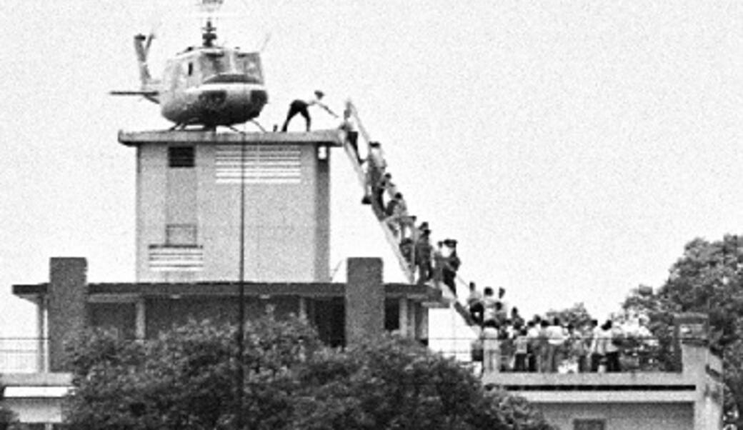 people climbing into helicopter on rooftop in Saigon