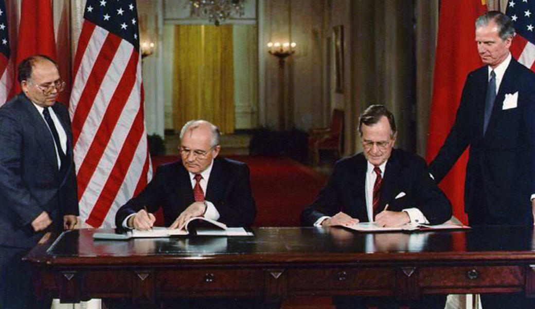 Bush and Gorbachev signing document side by side