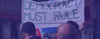Protesters in London with a sign that says 'Democracy must rule'