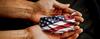 image of hands holding map of united states with flagf superimposed